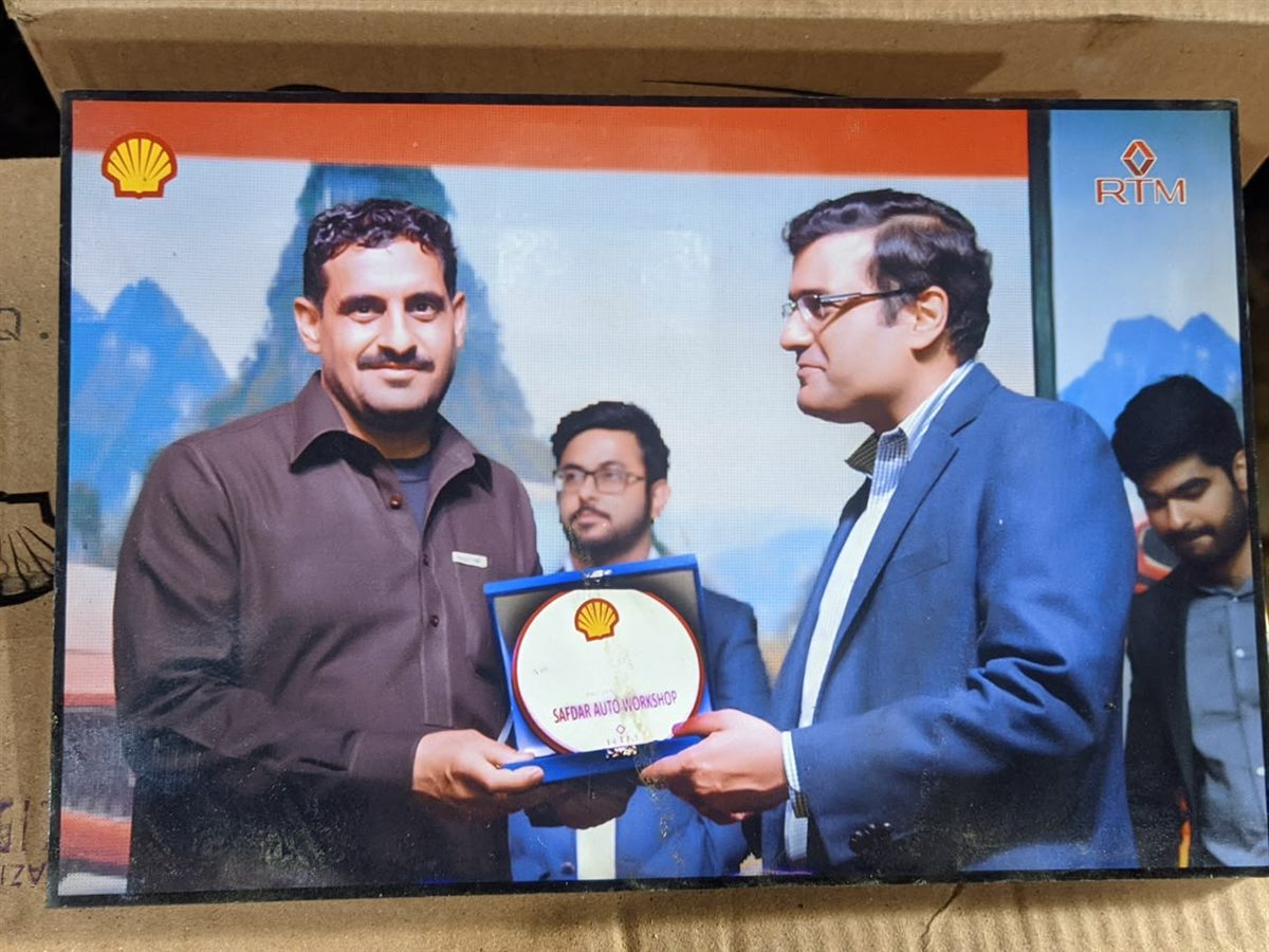 A Safdar Auto Workshop representative receiving a Shell and RTM recognition plaque