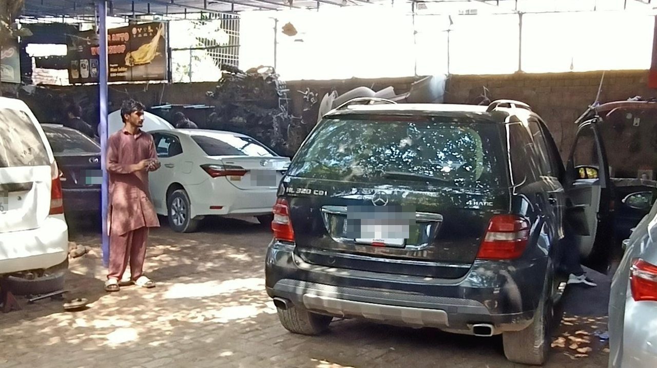 Safdar Auto Workshop yard with the workshop signboard and customer cars on Walton Road