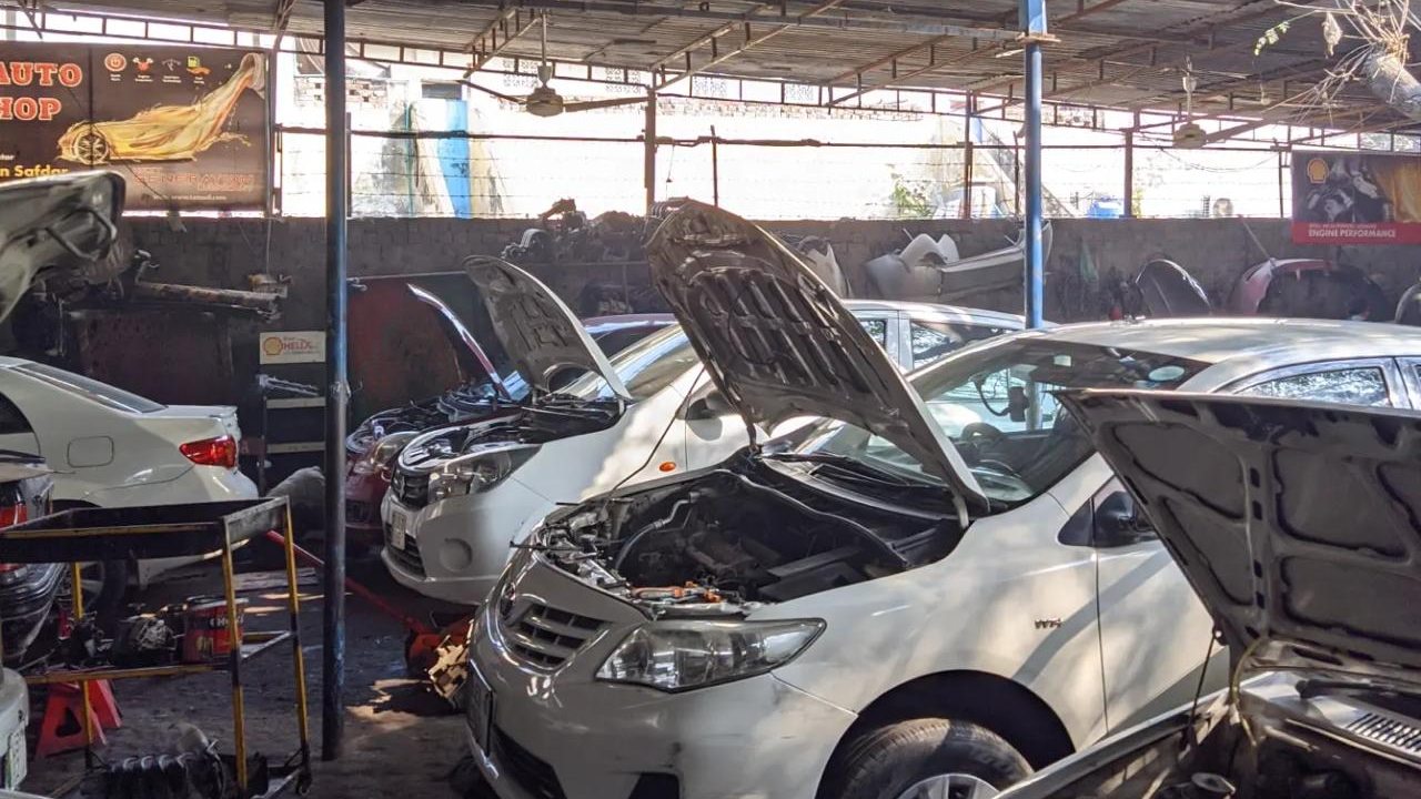 Cars with open bonnets being repaired in the Safdar Auto Workshop service bay
